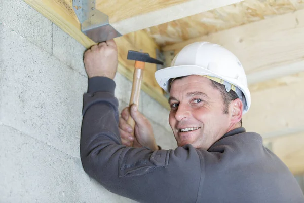 Reifer Bauarbeiter Mit Hammer Auf Dachbalken — Stockfoto