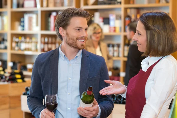 ワインショップで男性客と女性の売り手 — ストック写真