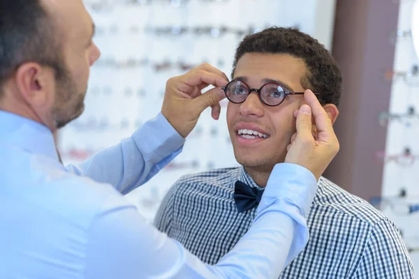 Adam Optik Mağazada Gülümserken Gözlük Deniyor — Stok fotoğraf
