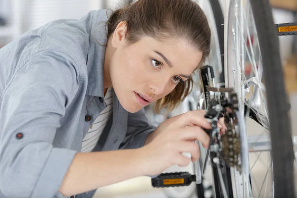 作業場でペンチや車輪の修理をしている女性は — ストック写真