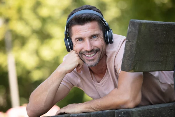 Schöner Junger Mann Mit Kopfhörern Chillt Auf Bank — Stockfoto