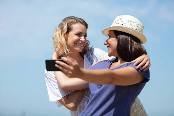Amigas Felices Tomando Selfie Contra Cielo Azul —  Fotos de Stock