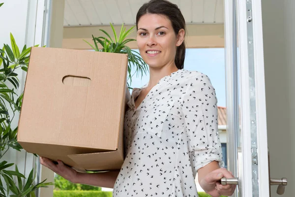 Kobieta Przenosi Się Nowym Mieszkaniu Trzymając Pudełko Kartonowe — Zdjęcie stockowe