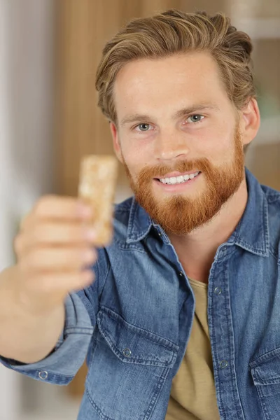 Handsome Young Man Eating Cereal Bar — Stock Photo, Image