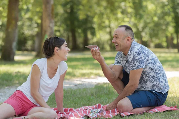 Para Średnim Wieku Siedzi Kocu Piknikowym Pod Drzewem — Zdjęcie stockowe