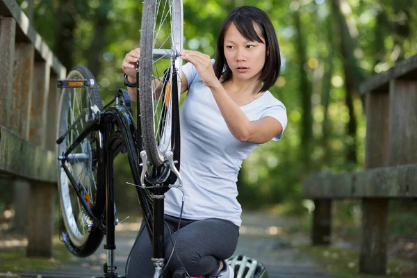 Mulher Está Consertando Bicicleta Parque — Fotografia de Stock