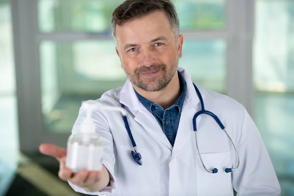Médico Mostrando Desinfetante Dispensador Para Câmera — Fotografia de Stock