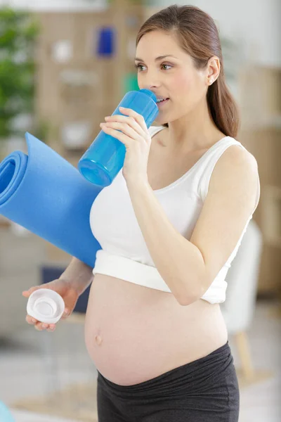 Gravid Sportig Kvinna Med Matta Och Flaska Vatten — Stockfoto