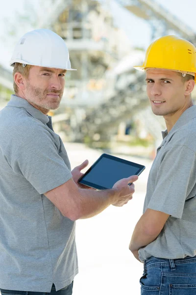 Zwei Männliche Ingenieure Die Ein Tablet Der Hand Halten Und — Stockfoto