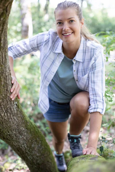 Mulher Caminhadas Está Subindo Sobre Tronco Árvore — Fotografia de Stock