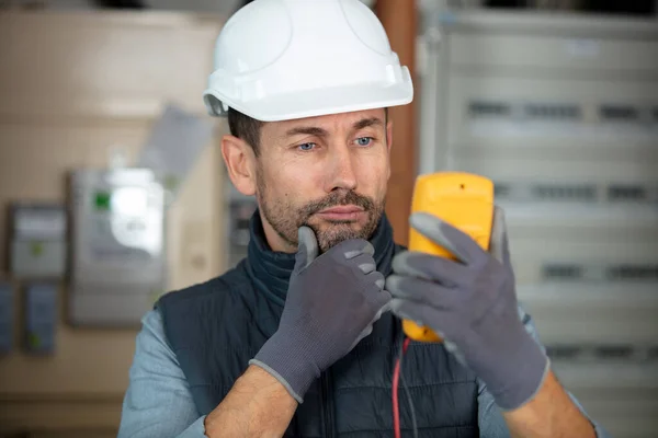 Puzzled Tradesman Staring His Multimeter — Stock Photo, Image