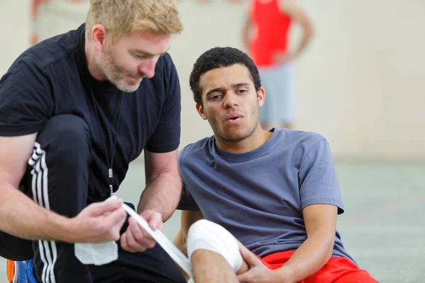 Coach Putting Bandage Players Injured Knee — Stock Photo, Image
