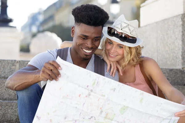 美しい若いカップルが地図を持って笑顔で — ストック写真
