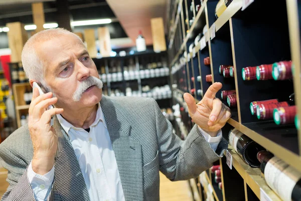 Uomo Anziano Telefono Durante Shopping Vino — Foto Stock