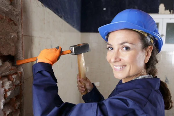 工作中带着锤子和凿子的快乐的女建筑工人 — 图库照片