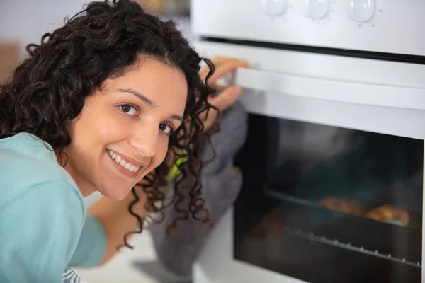 女人在烤箱里做饭 — 图库照片