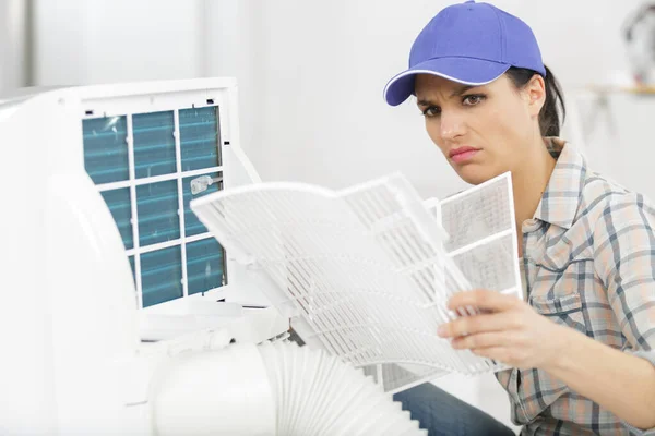 Young Woman Cleaning Air Conditioner Indoors — Stock Photo, Image