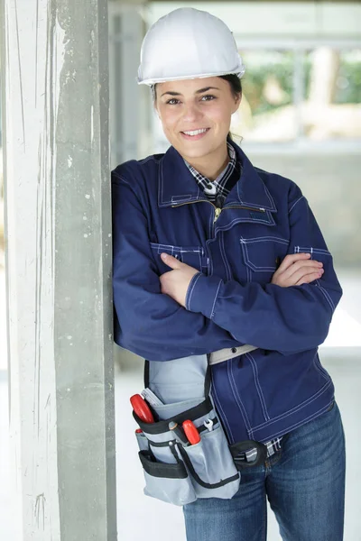 ヘルメットをかぶって壁にもたれかかる女性建築家 — ストック写真