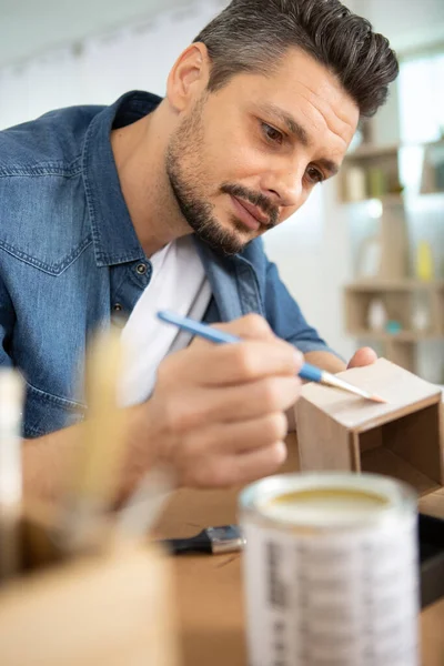 Homem Está Pintando Uma Caixa Madeira — Fotografia de Stock