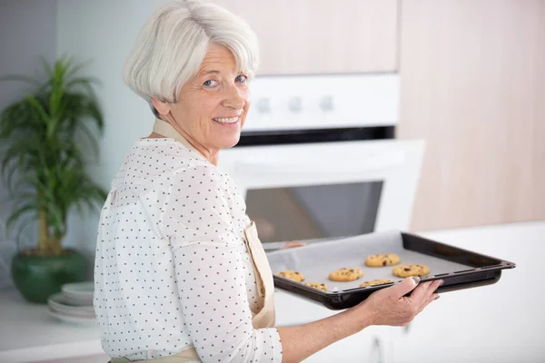 Starszy Kobieta Biorąc Tacę Świeże Ciasteczka Piekarnika — Zdjęcie stockowe