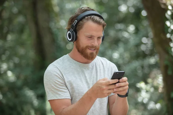 Jonge Man Met Ontspannen Het Park Zoek Naar Smart Phone — Stockfoto