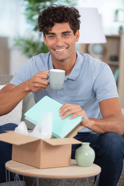 Young Man Opening Parcel Home — Stock Photo, Image