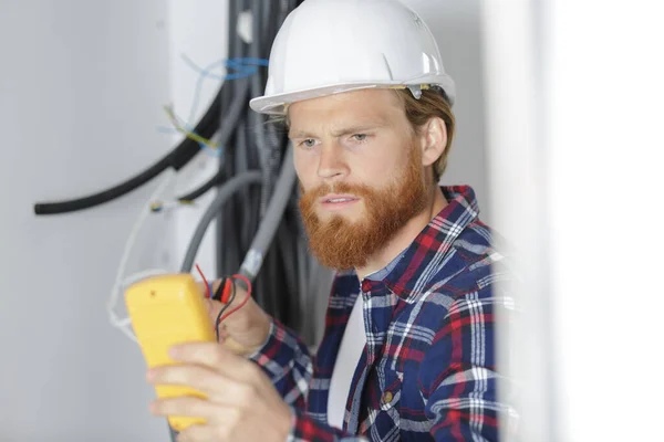 Puzzled Tradesman Staring His Multimeter — Stock Photo, Image