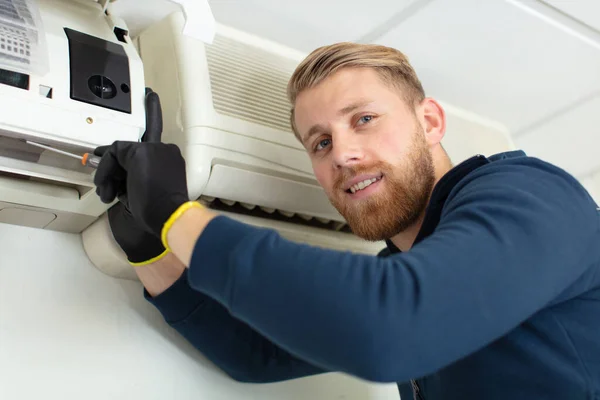 Mannelijke Technicus Repareert Airconditioner Met Schroevendraaier Binnen — Stockfoto