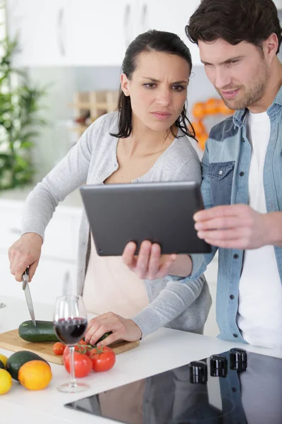 Casal Cozinhar Juntos Acordo Com Uma Receita Tablet — Fotografia de Stock