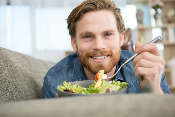 Adam Kanepeye Uzanıp Salata Yiyor — Stok fotoğraf