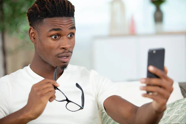 Jovem Homem Usando Seu Telefone Celular Olhando Surpreso Chocado — Fotografia de Stock