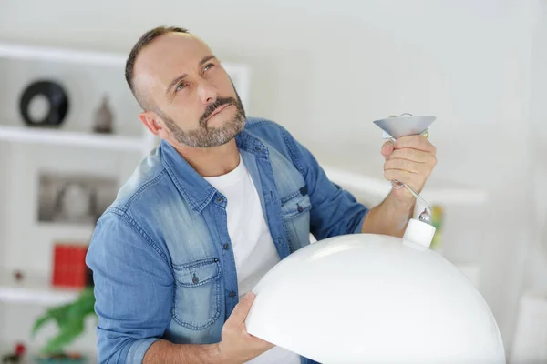 Hombre Pensando Instalar Una Lámpara —  Fotos de Stock
