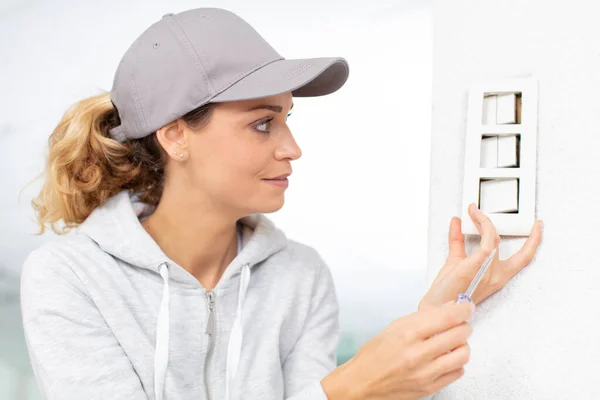 Concentrated Woman Fixing Plug — Stock Photo, Image