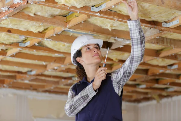 在天花板安装通风管的女电工 — 图库照片