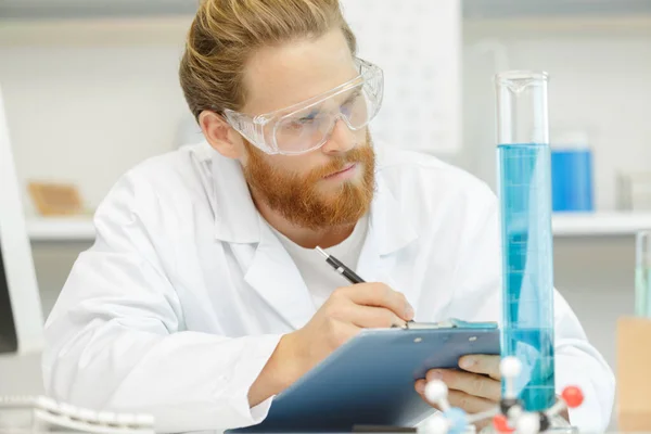 Handsome Young Male Scientist Wearing Protective Glasses Holding His Clipboard — Stock Photo, Image