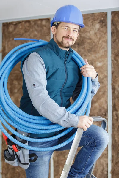 Male Tradesman Reel Blue Pipe His Shoulder — Foto de Stock