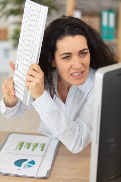 Mogen Kvinnlig Kontorsarbetare Hotar Att Slå Datorn Med Tangentbord — Stockfoto
