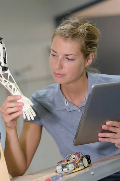 Frau Mit Tablet Blickt Auf Roboterhand — Stockfoto