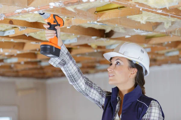 Female Builder Using Cordless Drill Wooden Ceiling Joist — Stock Photo, Image