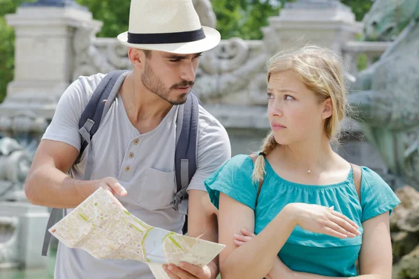 带着地图的男人给女朋友指明了正确的方向 — 图库照片