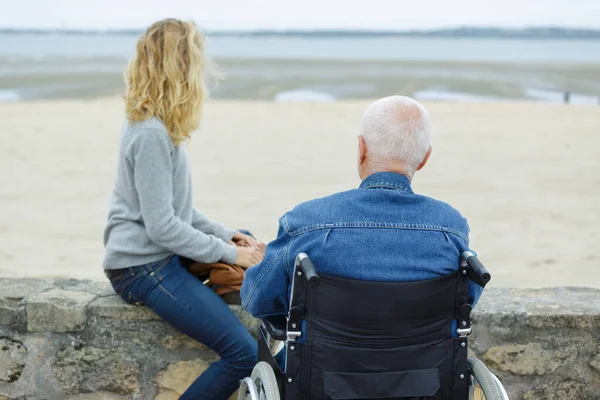 Mężczyzna Wózku Inwalidzkim Młoda Kobieta Patrząca Morze — Zdjęcie stockowe