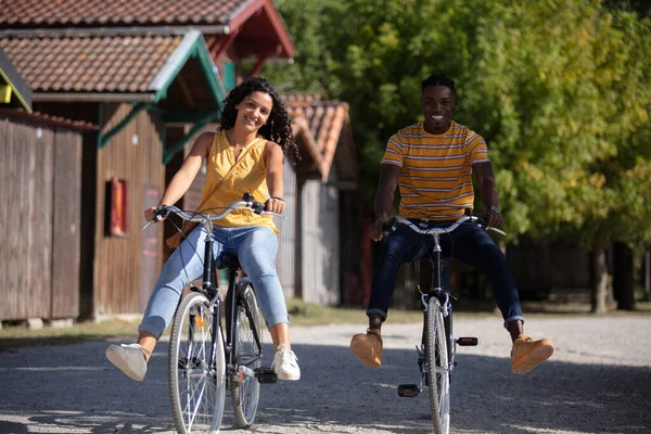 路地で自転車の上で笑顔のカップル — ストック写真