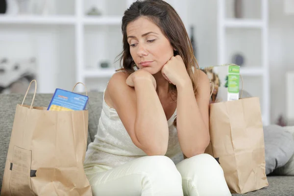 Donna Sul Divano Guardando Miseramente Sue Borse Generi Alimentari — Foto Stock
