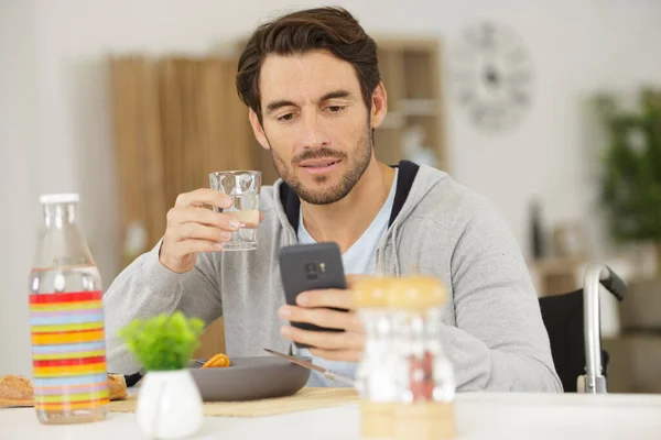 Deficiente Homem Olhando Para Smartphone Enquanto Come Sua Refeição — Fotografia de Stock