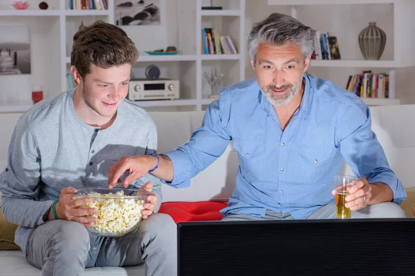 Otec Syn Sledování Televize Jíst Popcorn — Stock fotografie