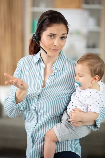 Multitasking Stress Zakenvrouw Werken Met Headset Met Haar Baby — Stockfoto