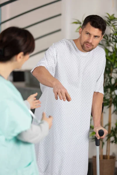 Arzt Spricht Mit Patient Auf Krücken Krankenhaus — Stockfoto