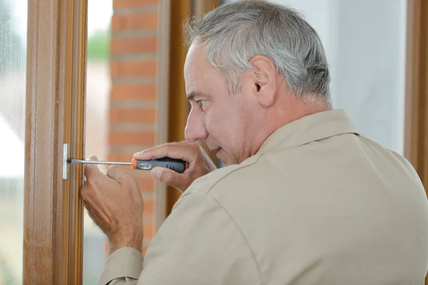 Mature Man Using Screwdriver Window — Stock Photo, Image