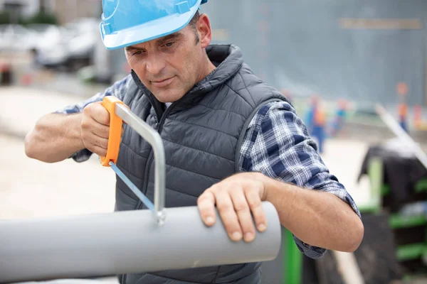 Plumber Sawing Plastic Pipe — Stock Photo, Image
