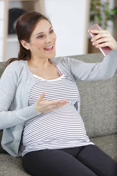 Νεαρή Έγκυος Γυναίκα Κάθεται Στον Καναπέ — Φωτογραφία Αρχείου